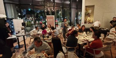People dining and conversing at a lively indoor restaurant event.