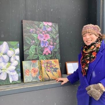 artist smiling beside her paintings of native ontario plants