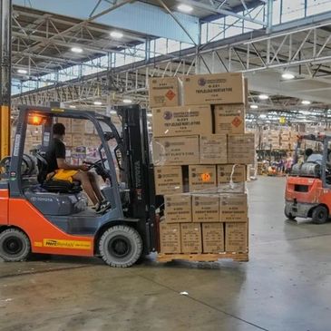 Forklift moving stacked boxes in a warehouse.