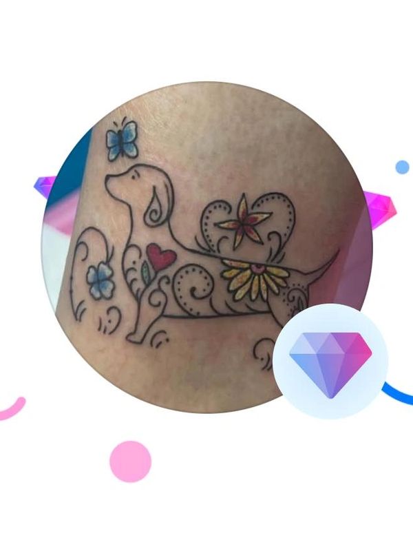 Colorful floral and butterfly tattoo on a dog outline.