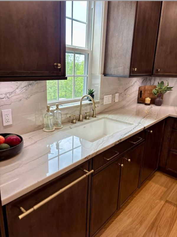 Modern kitchen countertop with marble finish and brass fixtures.