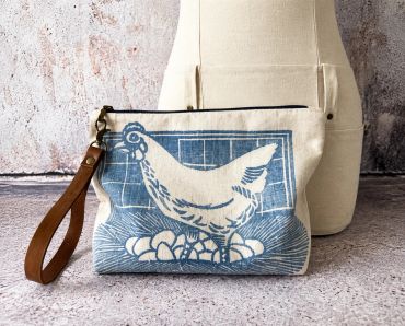 Fabric pouch with chicken design and wrist strap.