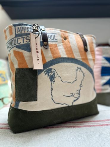 Canvas bag with a chicken print and leather handles.