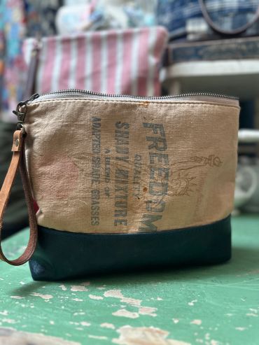 Canvas and leather zippered pouch with printed text.