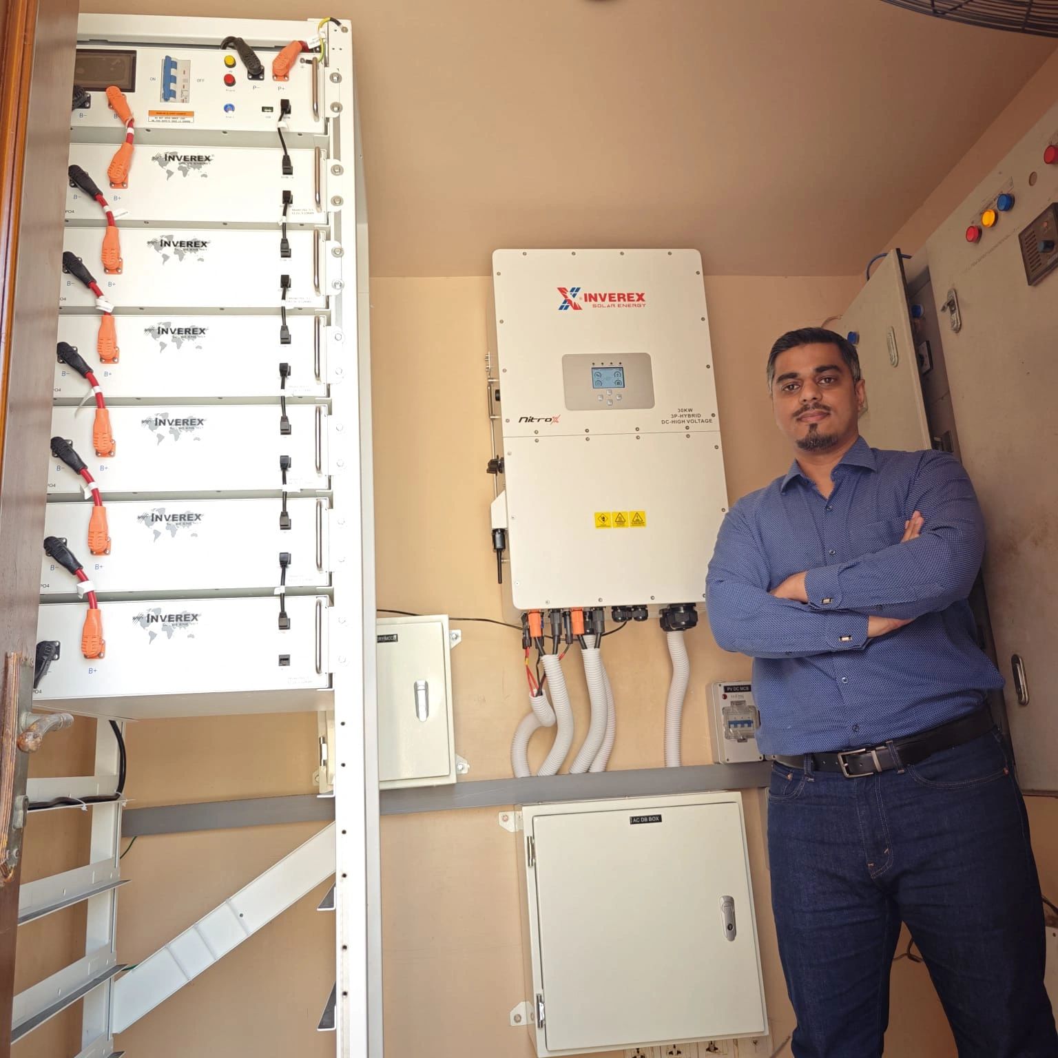 Man standing beside solar energy equipment.