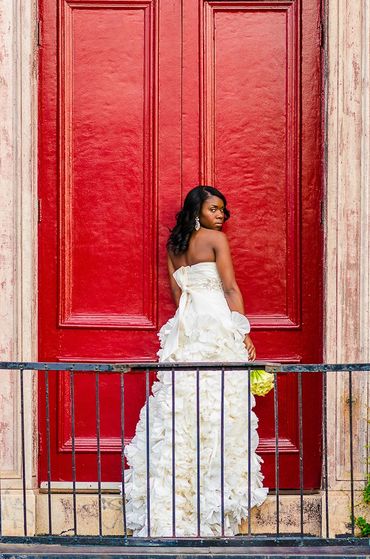 elegant photo of a bride in white in front of a bright red door