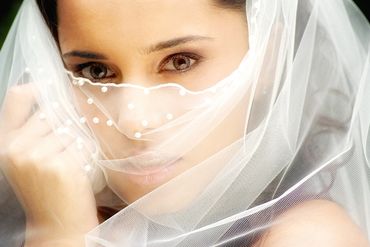 close-up of a beautiful bride peering above her veil
