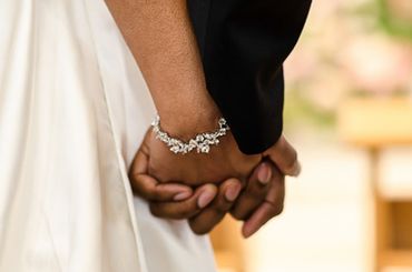close-up shot of the intertwined hands of a bride and groom