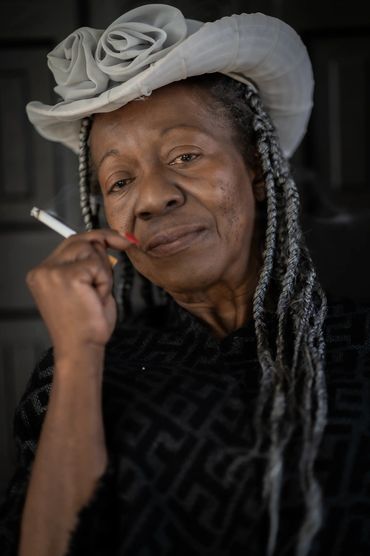 headshot of a silver haired baddie with a cigarette and an attitude.