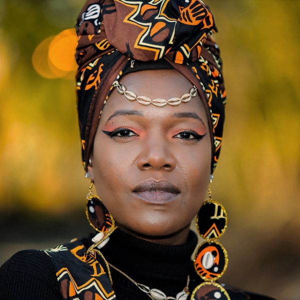 headshot photo of an exquisite African beauty in traditional headress and jewelry 