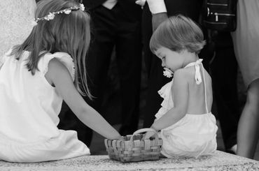 two little flowergirls paying close attention to their flower basket