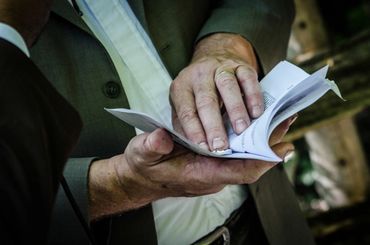 Detail shot of the officiants hands as he blesses the wedding rings