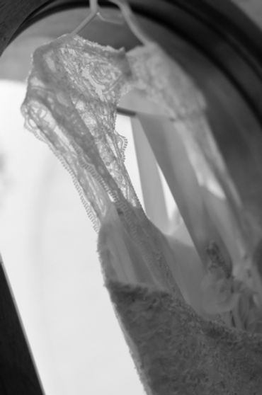 black and white detail photo of the wedding gown as it hangs in the window