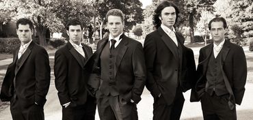 groom and his groomsmen in a cool pose on the street prior to the wedding