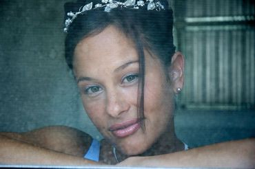 close-up of a bride seen trough the screen of her bedroom window