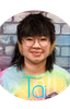 Smiling young person with glasses against a colorful background.