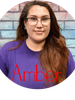 Portrait of a woman wearing glasses and a purple shirt.