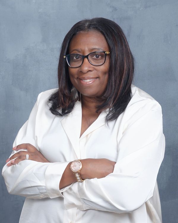 Confident woman in white shirt with glasses.