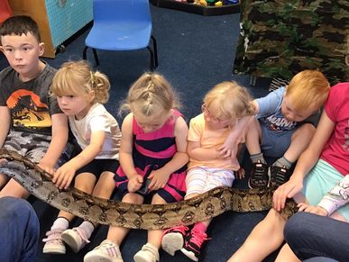 Children holding a snake