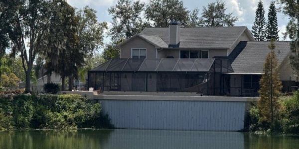 House with screened patio by a lake.