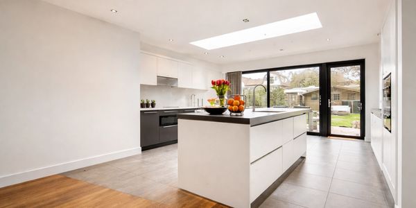 Modern kitchen with large island, skylight, and glass doors to backyard.