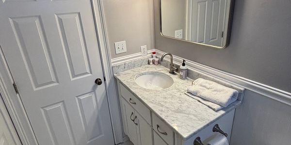 Clean bathroom vanity with marble countertop and mirror.