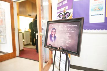 The photograph captures a solemn yet intimate moment inside a modest, historic black church