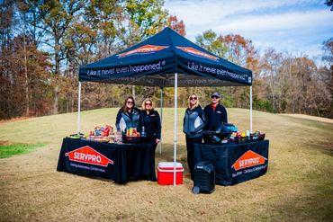 Servpro posing under their tent at Hospitality Tourisum Alliance Golf Tournerment