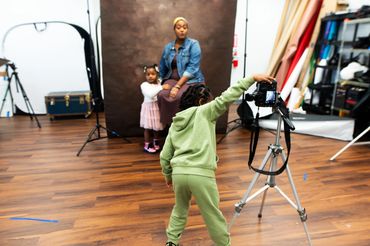 son taking a portrait of his sister & mother