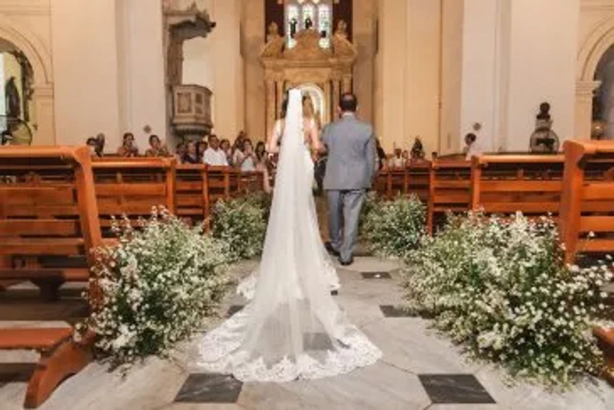  La novia entra majestuosa a la iglesia colonial. Un velo de amor en esta boda cartagenera.