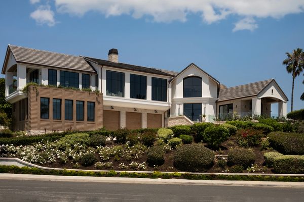Large modern house with manicured garden under a blue sky.
