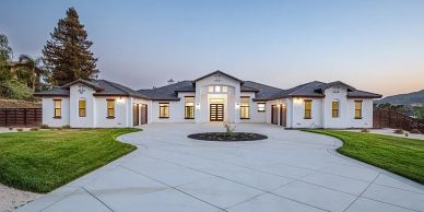 Luxury single-story modern mansion with large driveway.