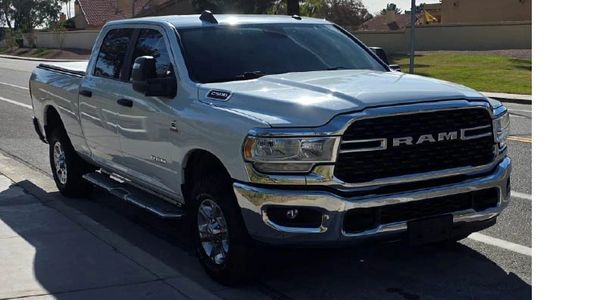 Silver RAM pickup truck parked on a sunny street.