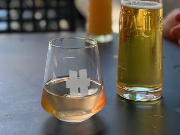 Two drinks on a table, one in a glass and one in a tall glass.
