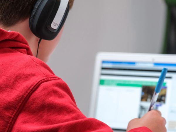 a boy wearing a red shirt, doing his homework.