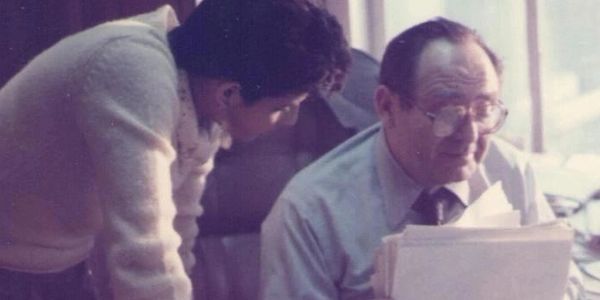 Two men reviewing documents in an office setting.