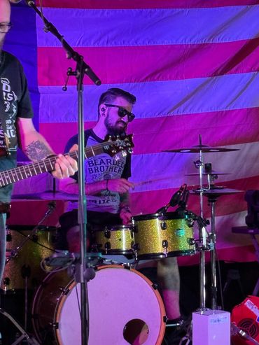 Drummer playing in front of an American flag.