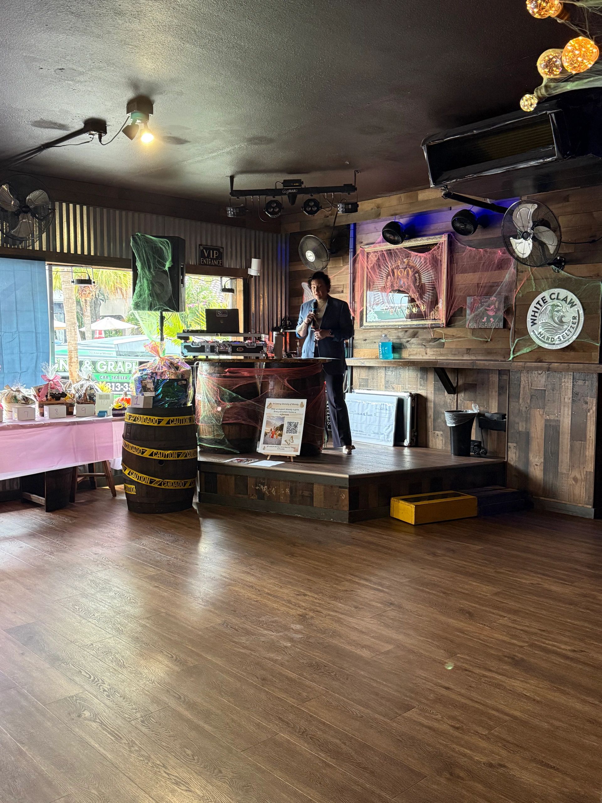 Person speaking on a decorated stage inside a venue.