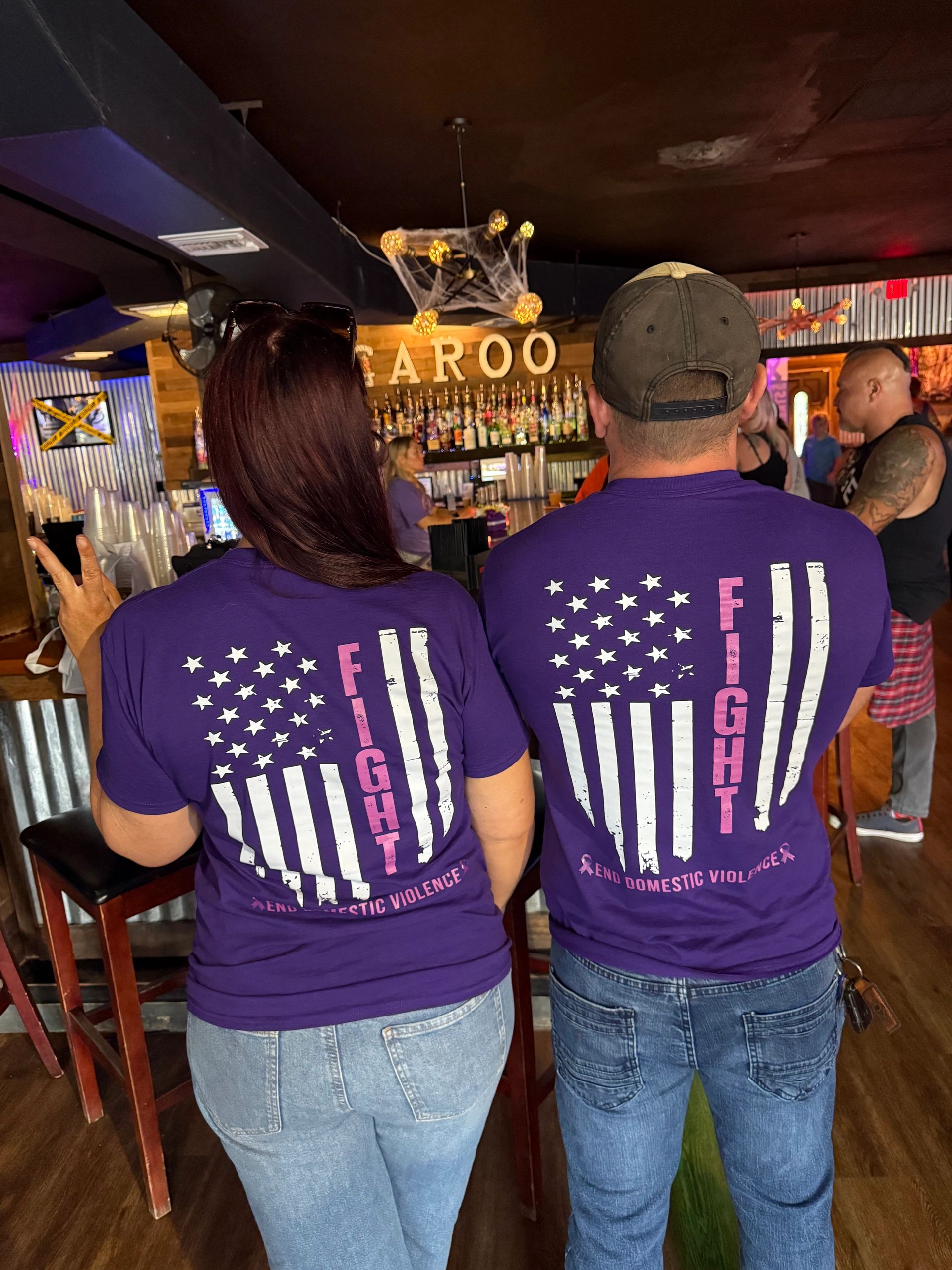 Two people wearing purple shirts supporting end to domestic violence.