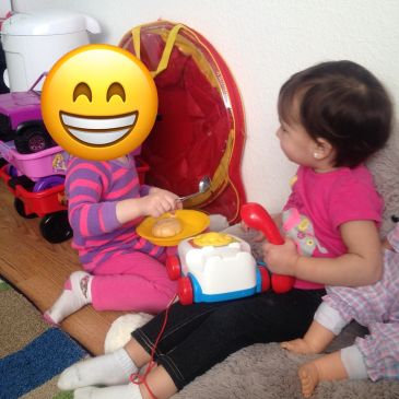 Two young children playing indoors with toys.