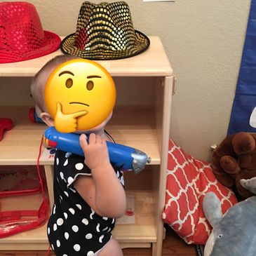 Toddler playing with a toy phone indoors.