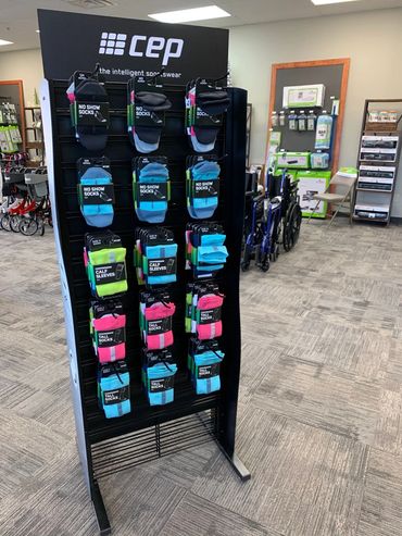 Display rack of colorful CEP compression socks and calf sleeves in a store.