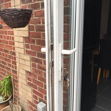 Open white French door with keys in lock