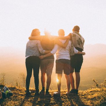 four people with hands on shoulder and waste 