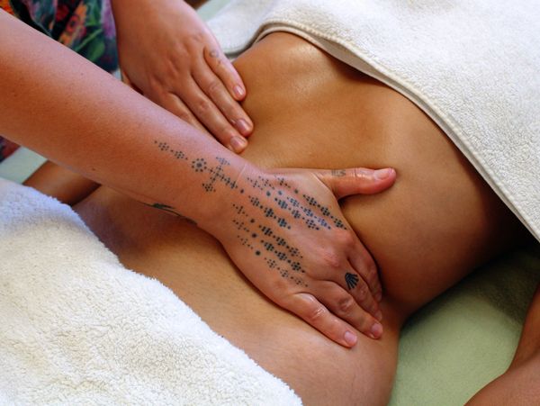 Tattooed hands giving a relaxing back massage.