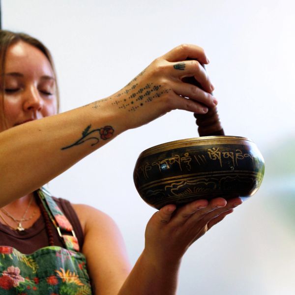 Woman using a Tibetan singing bowl for meditation or healing.