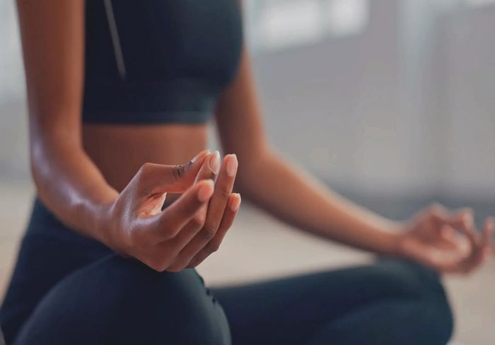 Person meditating in a calm indoor setting.