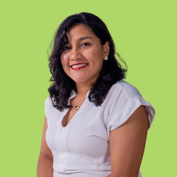 Smiling woman with dark hair wearing a white blouse against a green background.