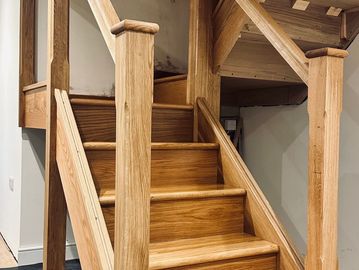 Newly installed wooden staircase with sturdy handrails.