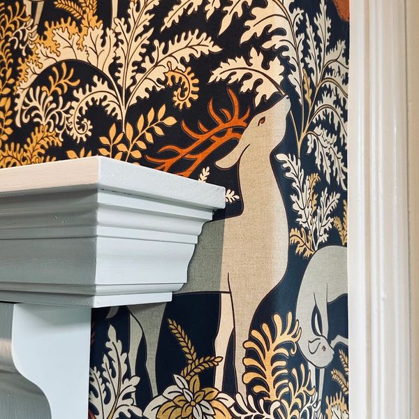 Decorative wallpaper with deer and foliage in earthy tones.